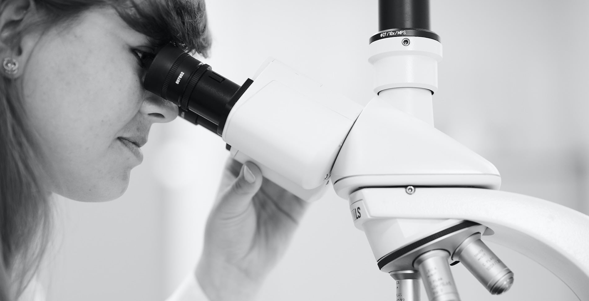 laborantine qui regarde dans un microscope
