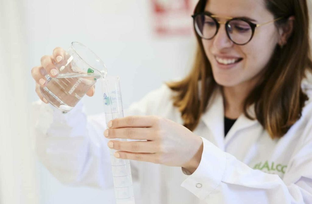 Femme qui manipule des fioles de produits dans un laboratoire